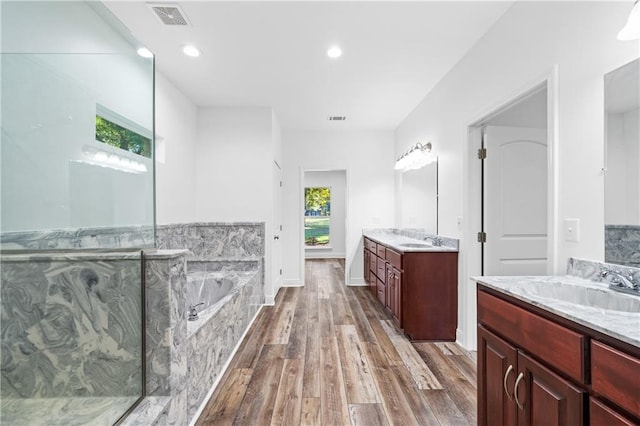 bathroom with hardwood / wood-style floors, a bathtub, and vanity