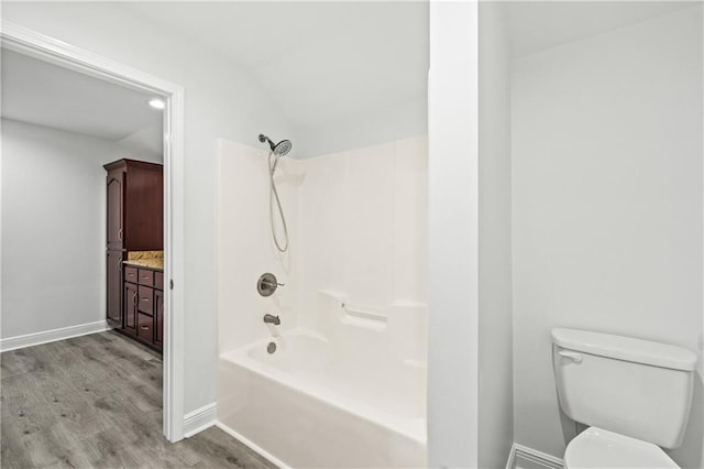 bathroom with hardwood / wood-style floors, toilet, and bathtub / shower combination