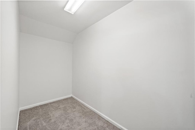 empty room with vaulted ceiling and light carpet