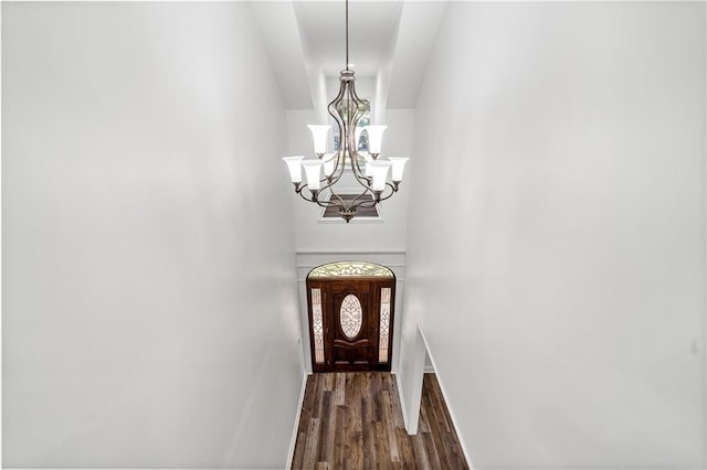 doorway to outside with dark wood-type flooring and an inviting chandelier