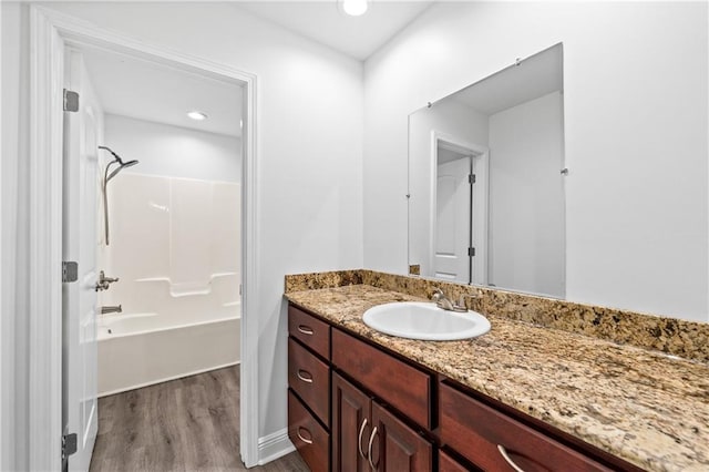 bathroom featuring washtub / shower combination, hardwood / wood-style flooring, and vanity