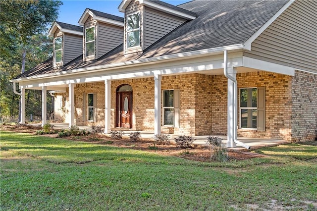 view of front of house featuring covered porch and a front lawn