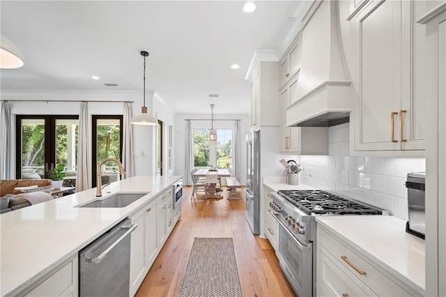 313 Cuban Lilly Dr, Fairhope, AL 36532 - kitchen with premium range hood, premium appliances, a sink, light countertops, and light wood finished floors