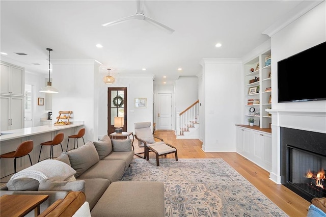 313 Cuban Lilly Dr, Fairhope, AL 36532 - living area with a premium fireplace, crown molding, light wood-type flooring, recessed lighting, and stairway