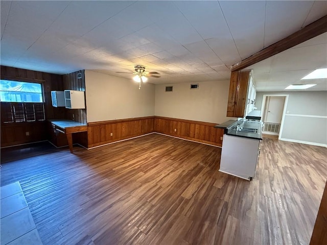 6 Elizabeth Ave, Chickasaw, AL 36611 - kitchen with wood walls, dark wood-style floors, a ceiling fan, wainscoting, and dark countertops