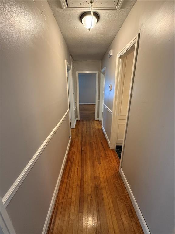 6 Elizabeth Ave, Chickasaw, AL 36611 - hallway featuring wood-type flooring and a textured ceiling