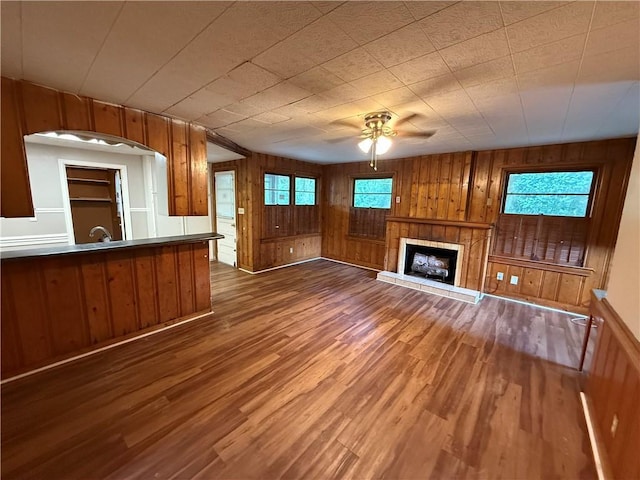 6 Elizabeth Ave, Chickasaw, AL 36611 - unfurnished living room featuring wood finished floors, wood walls, ceiling fan, and a tile fireplace