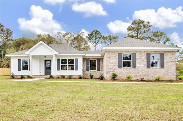 view of front of property with brick siding, roof with shingles, and a front lawn