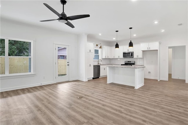 kitchen featuring decorative backsplash, visible vents, open floor plan, and stainless steel appliances