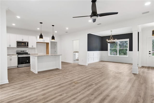 kitchen featuring open floor plan, white cabinets, stainless steel appliances, and light wood-style flooring