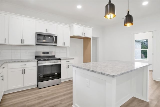 kitchen featuring crown molding, light wood-style flooring, and appliances with stainless steel finishes