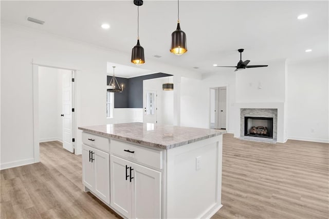 kitchen with visible vents, a center island, light wood-style floors, and ceiling fan
