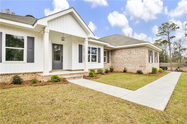 view of front of property with a front yard and roof with shingles