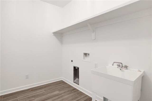 laundry room featuring electric dryer hookup, washer hookup, wood finished floors, baseboards, and laundry area