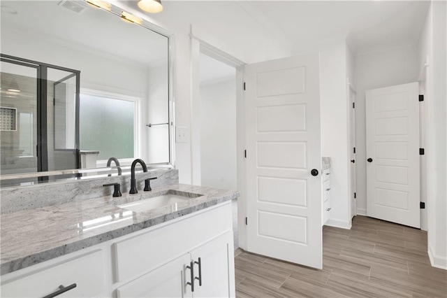 bathroom featuring visible vents, wood tiled floor, a shower stall, and vanity
