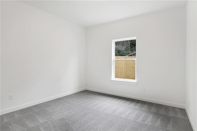 unfurnished room with baseboards and carpet floors
