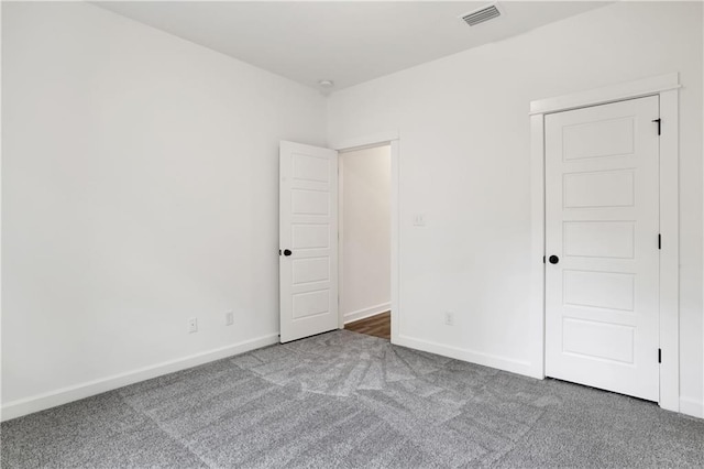 spare room featuring visible vents, baseboards, and carpet