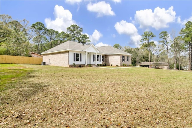 view of front of home featuring a front lawn, central AC unit, and fence