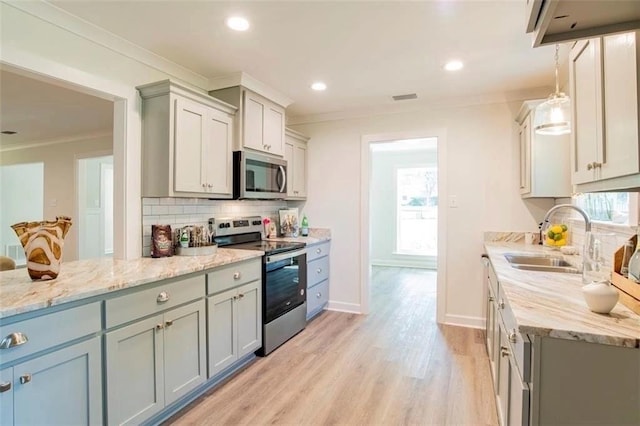 kitchen featuring sink, light hardwood / wood-style floors, stainless steel appliances, and a healthy amount of sunlight