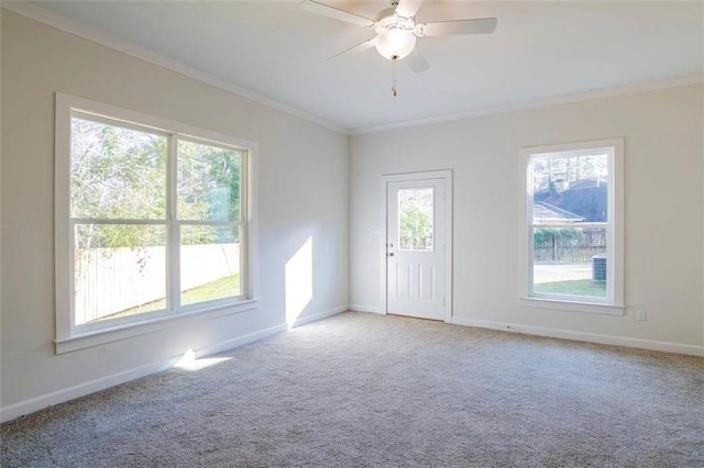 spare room with crown molding, light colored carpet, and a healthy amount of sunlight