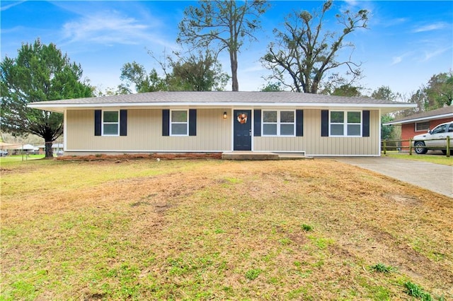 ranch-style home featuring driveway and a front lawn