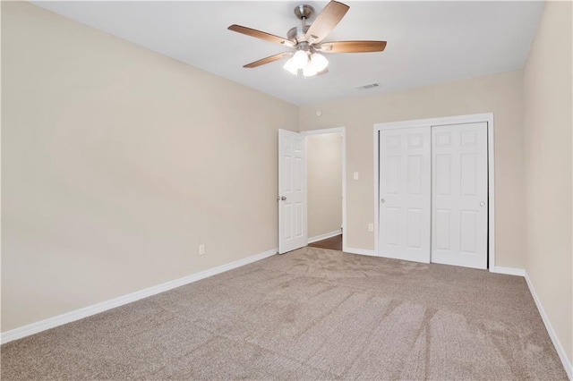 unfurnished bedroom with carpet flooring, a ceiling fan, visible vents, baseboards, and a closet