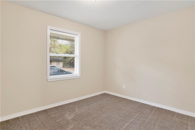 spare room featuring carpet floors and baseboards