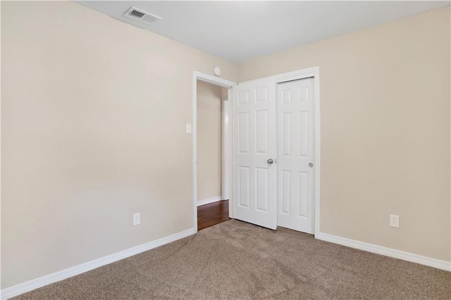 unfurnished bedroom featuring carpet floors, a closet, visible vents, and baseboards