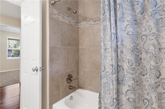 bathroom with shower / bath combo and baseboards