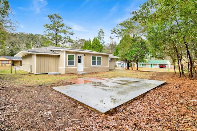 back of property with a patio area, fence, and brick siding