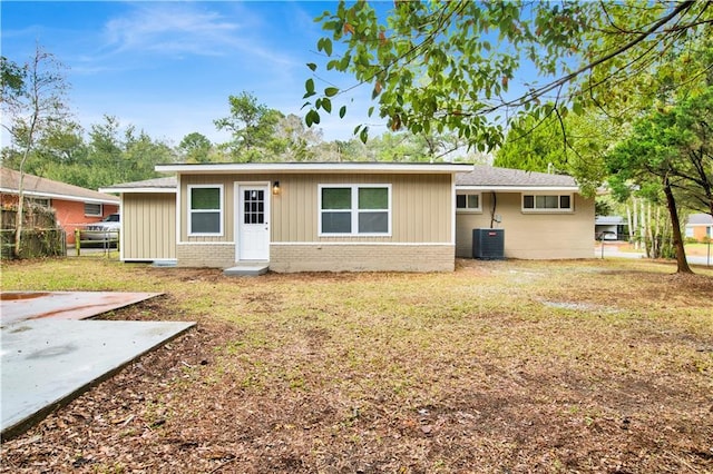 view of front of home with brick siding, a front lawn, and cooling unit