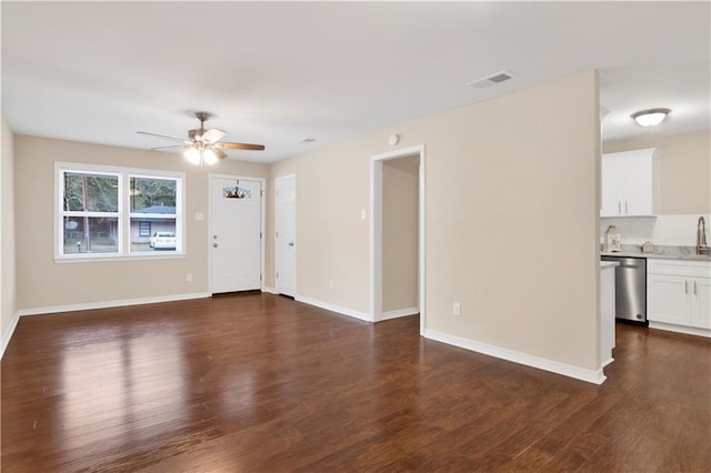 unfurnished living room with a ceiling fan, visible vents, dark wood finished floors, and baseboards