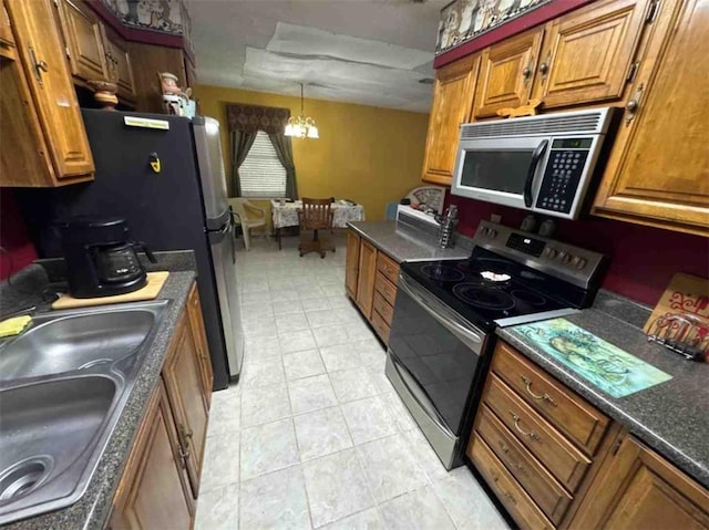 kitchen featuring pendant lighting, sink, stainless steel appliances, light tile patterned flooring, and a chandelier