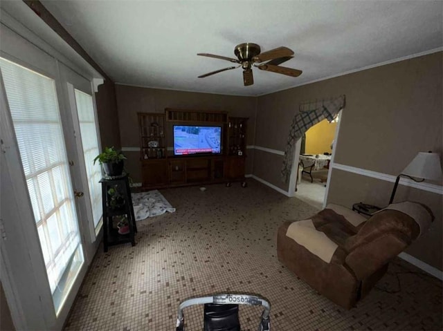 unfurnished living room featuring crown molding, a healthy amount of sunlight, and ceiling fan