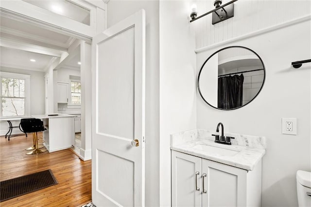 bathroom with curtained shower, vanity, toilet, ornamental molding, and hardwood / wood-style flooring