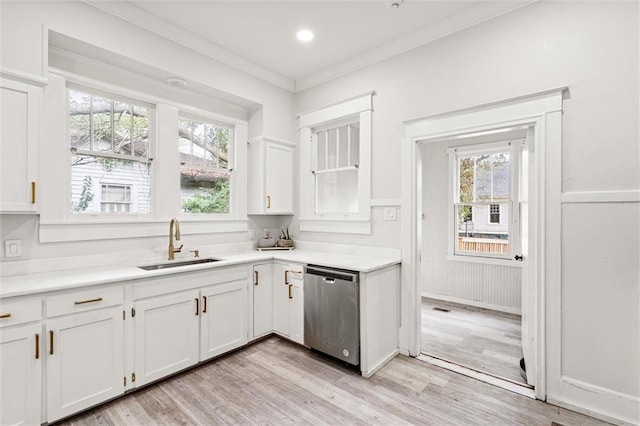 kitchen featuring light wood-type flooring, crown molding, stainless steel dishwasher, white cabinets, and sink