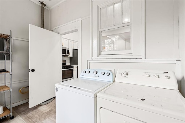 laundry room featuring light wood-type flooring and separate washer and dryer