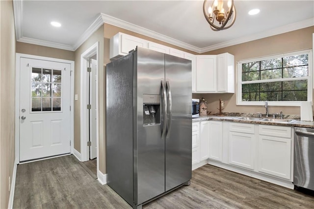 kitchen featuring sink, appliances with stainless steel finishes, ornamental molding, light stone countertops, and white cabinets