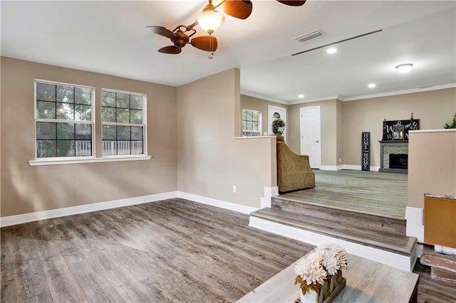 unfurnished living room with a healthy amount of sunlight, wood-type flooring, and a stone fireplace