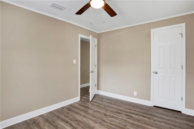 spare room with crown molding, ceiling fan, and dark hardwood / wood-style floors