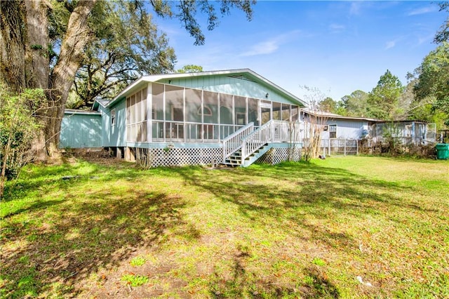 back of house with a lawn and a sunroom