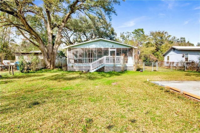 back of property featuring a yard and a sunroom