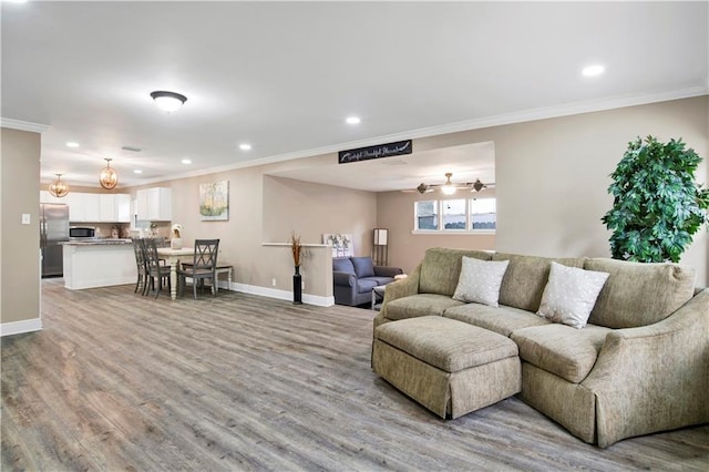 living room with crown molding, ceiling fan, and light hardwood / wood-style floors