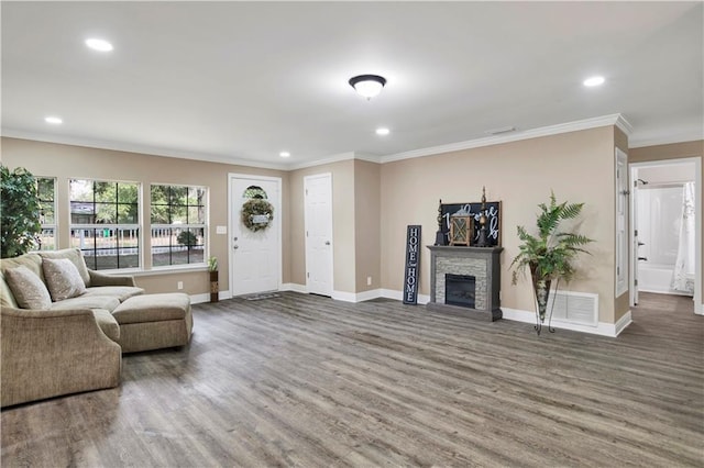 living room featuring ornamental molding, a stone fireplace, and dark hardwood / wood-style flooring