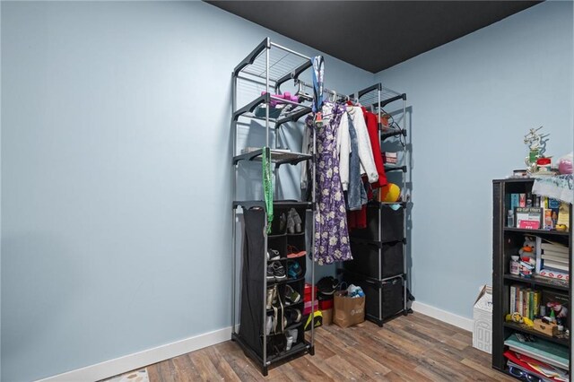 walk in closet with dark wood-type flooring