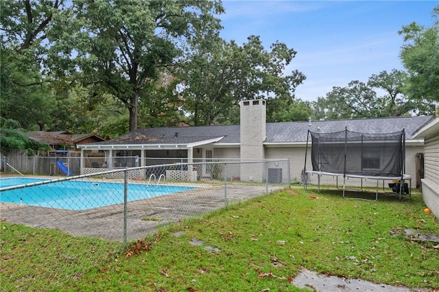 view of swimming pool featuring a trampoline, a yard, and a patio