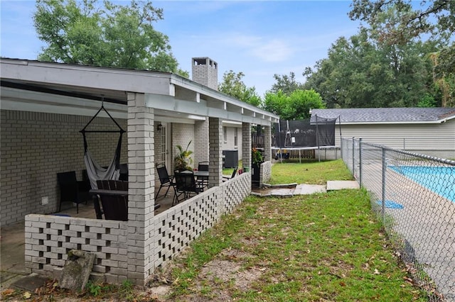 view of yard with cooling unit, a trampoline, and a patio