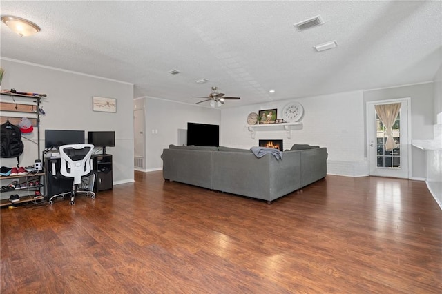 living room with a textured ceiling, ceiling fan, and dark wood-type flooring