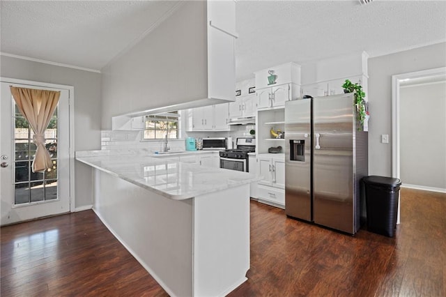 kitchen featuring sink, dark hardwood / wood-style floors, white cabinetry, kitchen peninsula, and stainless steel appliances