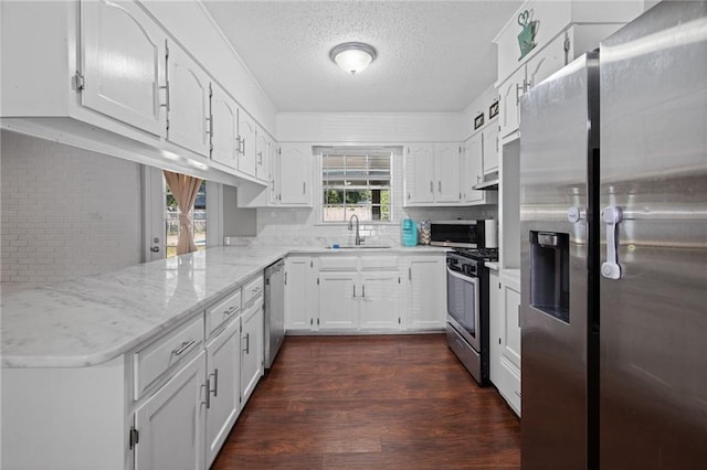 kitchen with white cabinetry, sink, stainless steel appliances, dark wood-type flooring, and kitchen peninsula